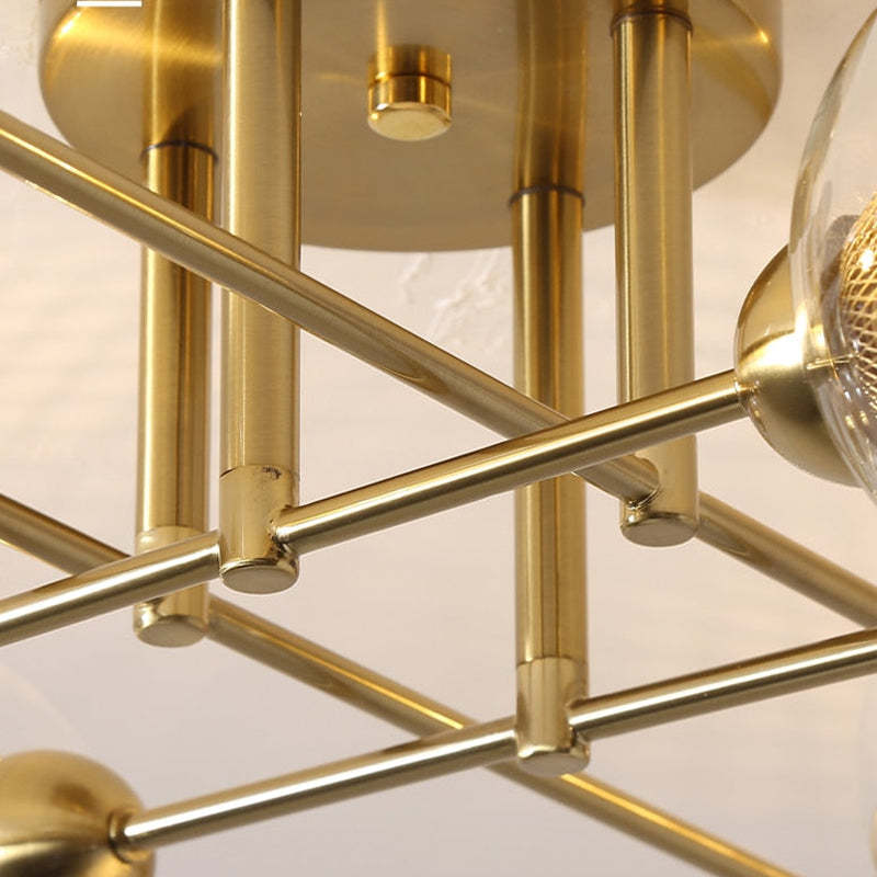 Close-up of the brushed-gold canopy and crossing rods on the Clérachic sputnik chandelier, showing the turned socket cups.