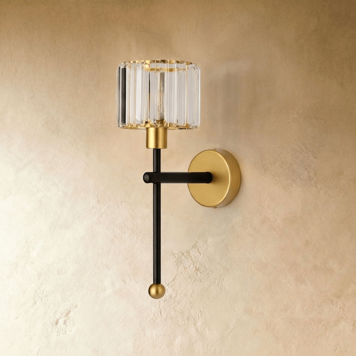 Clérachic wall lamp in black and brass with a fluted clear glass shade and ball finial, switched off on plaster.