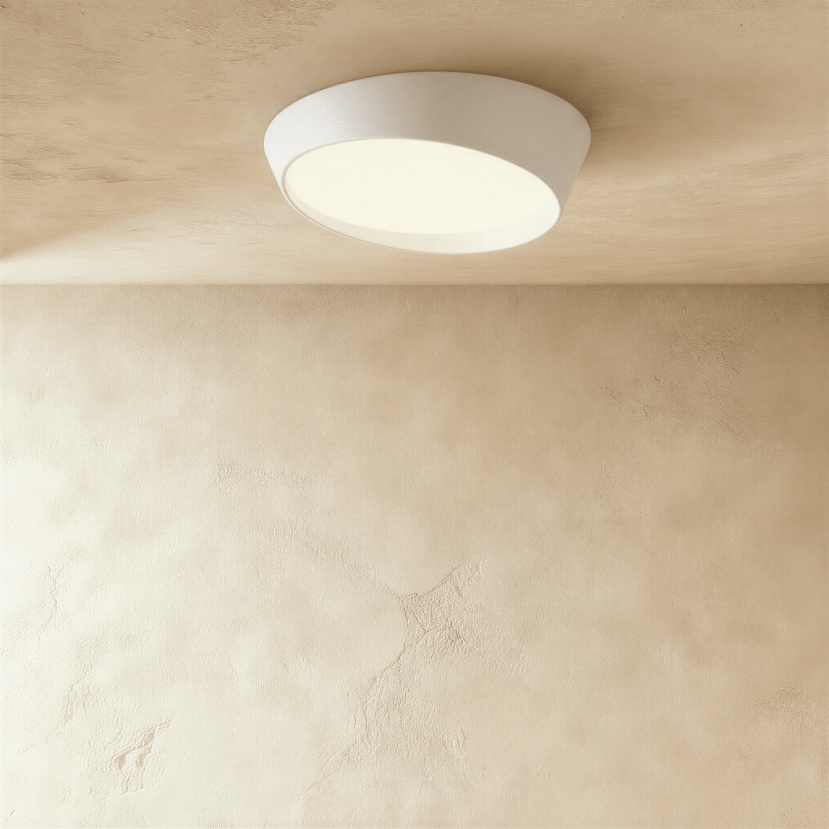 Clérachic larger white round ceiling light with an angled iron body and a softly lit frosted diffuser on a limewash ceiling.