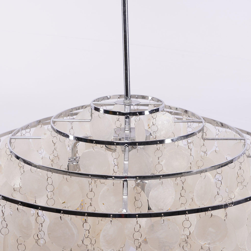 Looking up the chrome stem to the stepped chrome rings at the crown of this Clérachic shell chandelier.