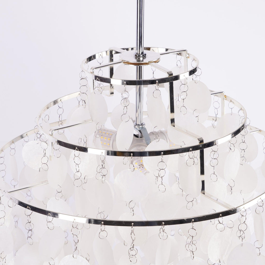Close view of the chrome frame and a bulb inside this Clérachic shell chandelier, seen between white discs.