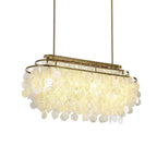 Long oval Clérachic shell chandelier on two gold rods, lit warm, with its discs hanging below the oval frame.