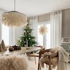 Clérachic shell chandelier at the corner of the frame in a bright dining room with a Christmas tree and sheepskin throws.