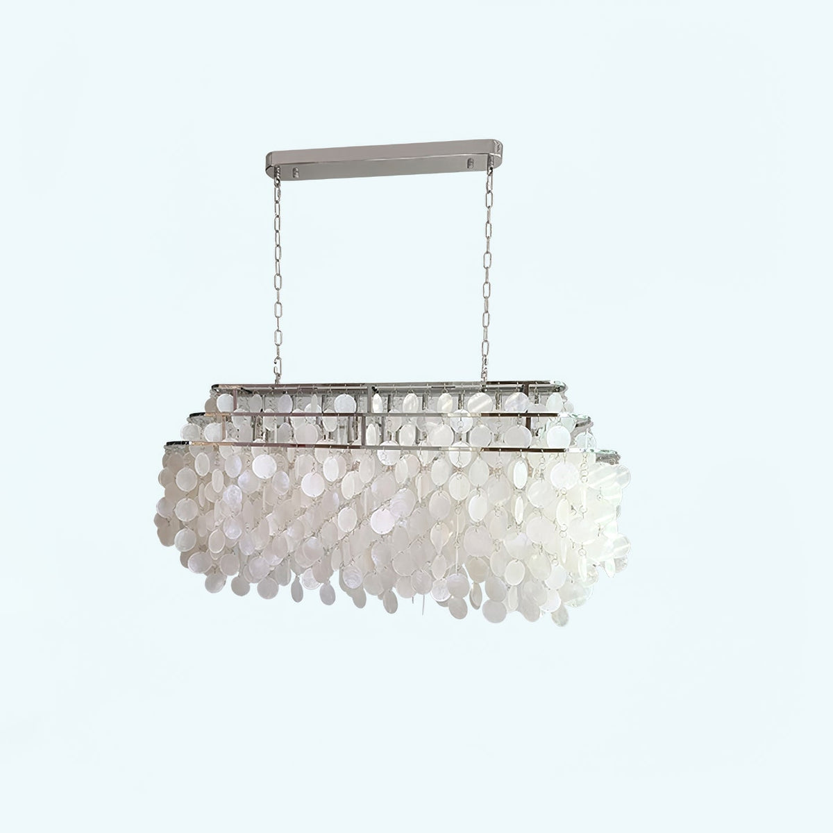 Rectangular Clérachic shell chandelier with a chrome bar, hung on two chains, on a pale blue-white backdrop.