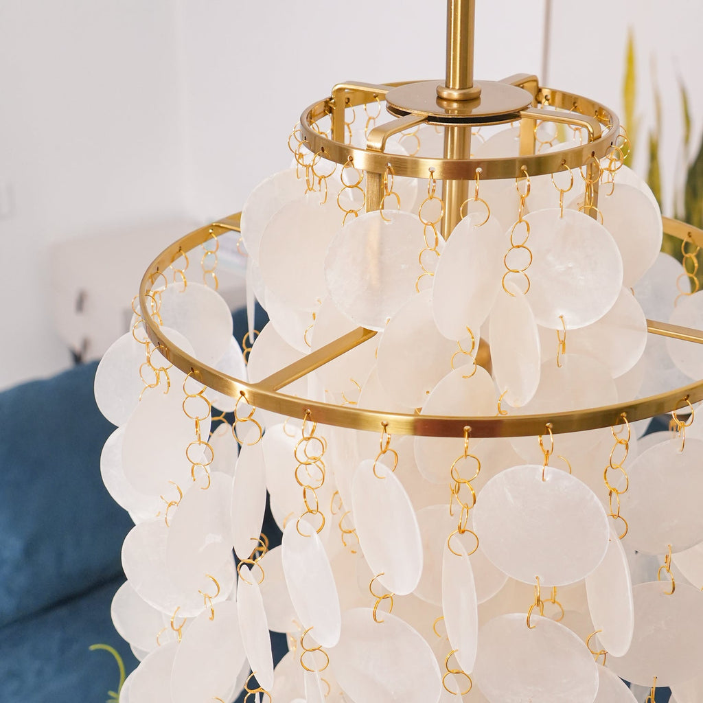 Close view of the gold rings, spoke frame and shell discs on small gold links at the crown of this Clérachic chandelier.