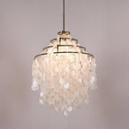 Lit tall gold-ringed Clérachic shell chandelier with four tiers of discs, glowing warm white on a lilac backdrop.