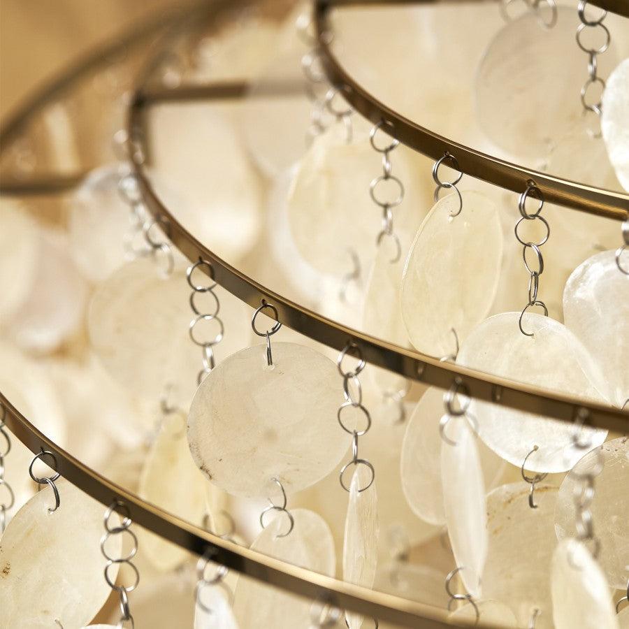 Close view of the gold rings and metal links holding the shell discs on this Clérachic chandelier.