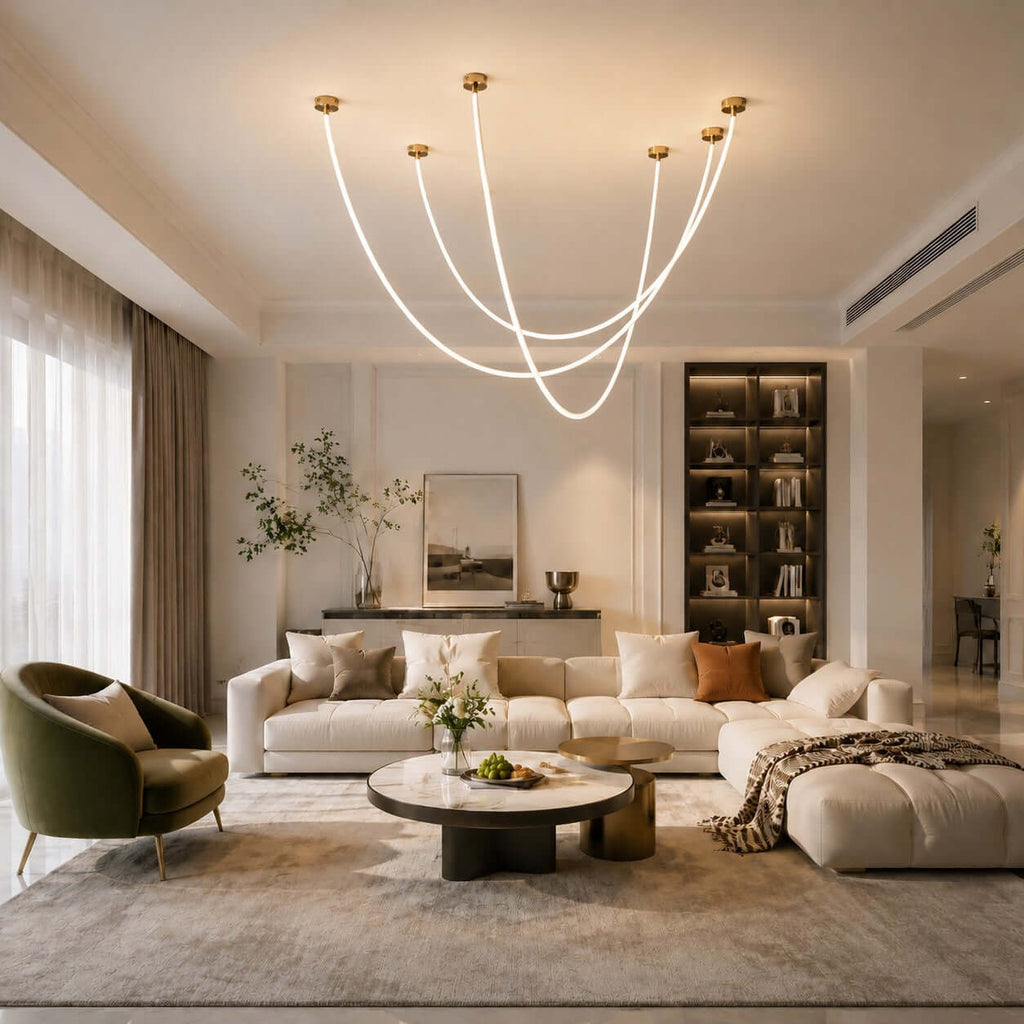 Several glowing tubes of this Clérachic pendant light sweep in loops over a cream sofa and round coffee table in a large living room.