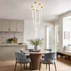 Five lit tubes of this Clérachic pendant light fall in long lines above a round dining table with blue-grey chairs.