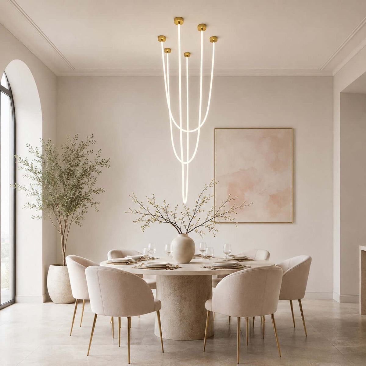 A tall cluster of lit tubes from this Clérachic pendant light hangs over a round stone dining table in an arched-window room.
