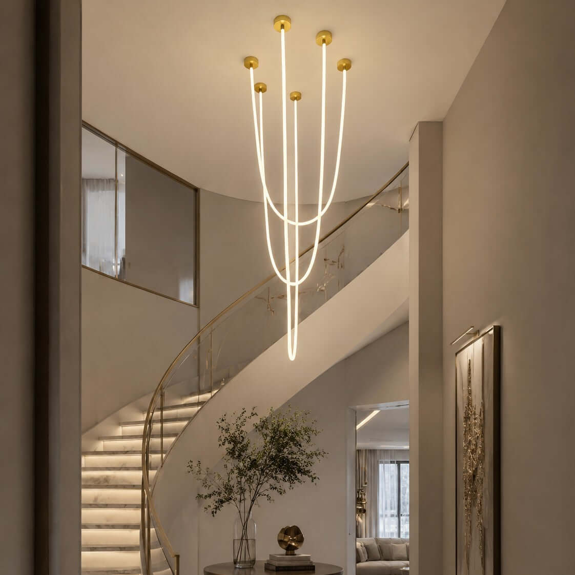 Beside a curved staircase with lit steps, this Clérachic pendant light drops its long glowing tubes at different heights.