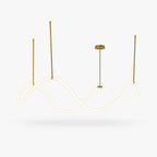 A Clérachic pendant light with a glowing wave-shaped silicone strip hung from gold-toned rods and a round canopy, on a white backdrop.