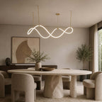 This Clérachic wave pendant glows over a pale stone dining table with sculpted boucle chairs and an abstract painting behind.