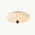 Cut-out view of a Clérachic flush-mount ceiling light with a white pleated silk-look shade and a round walnut-colour finial, on white.