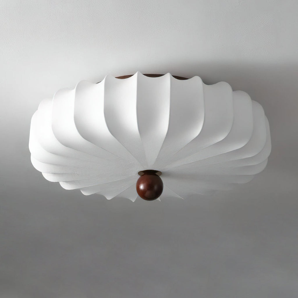 Unlit white pleated shade with a walnut-colour finial on this Clérachic ceiling light, seen from below against a grey ceiling.