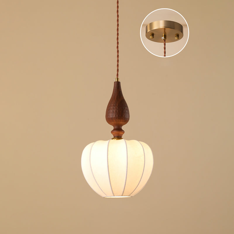 A taller rounded shade on this Clérachic pendant against a tan backdrop, with an inset showing the round brass ceiling plate.
