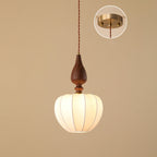 A taller rounded shade on this Clérachic pendant against a tan backdrop, with an inset showing the round brass ceiling plate.