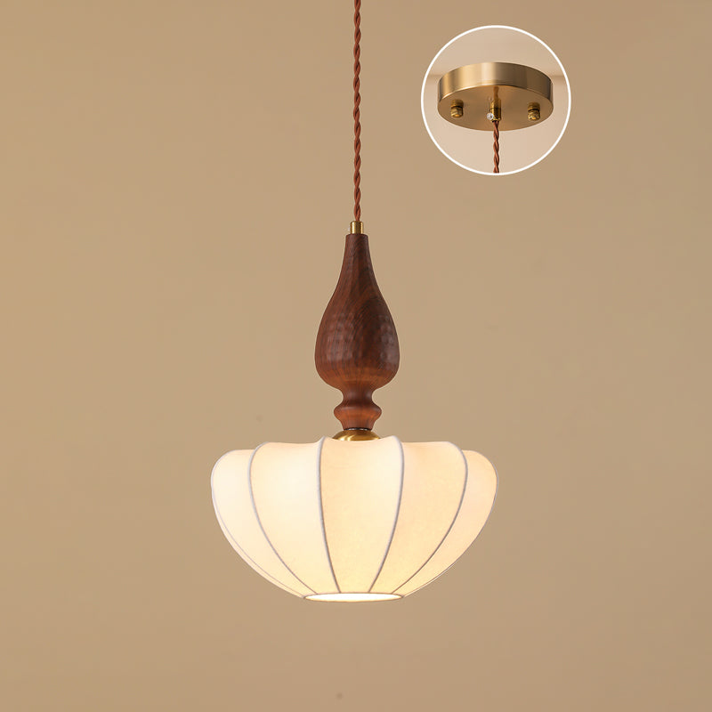 Wide, flatter shade on a Clérachic pendant with a wooden top, on a tan backdrop with the brass ceiling plate shown in an inset.