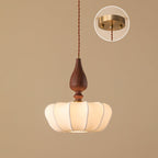 Compact wide shade on this Clérachic pendant, lit from below, with an inset of the brass ceiling plate on a tan backdrop.