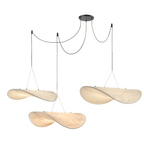 Three twisted white pendants hang at varied heights from a black ceiling canopy on looped black cables, a Clérachic pendant cluster.