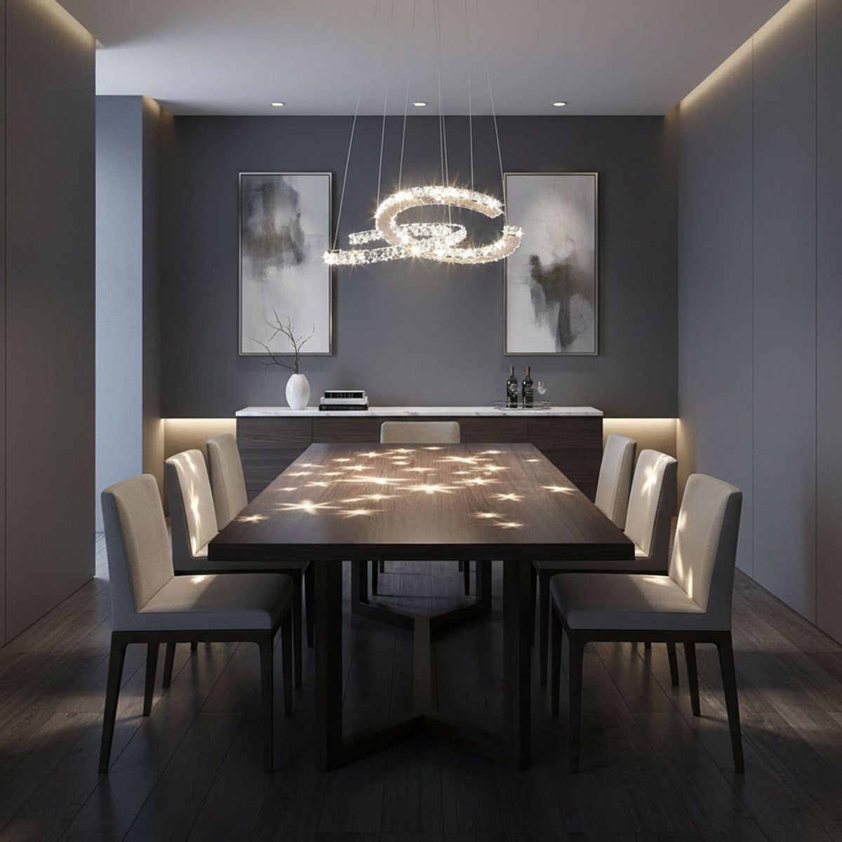 Crystal crescent pendant from Clérachic above a dark dining table, with spots of light scattered across the table top.