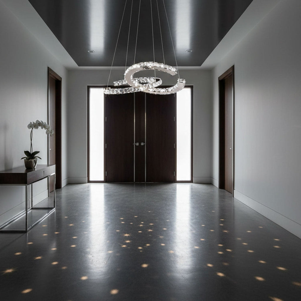 Wide hallway with dark doors and a Clérachic crystal pendant, its light breaking into small stars on the glossy floor.