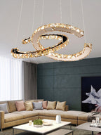 Cognac-toned Clérachic crystal pendant above a sofa with pastel cushions, in a living room with a dark green wall.