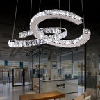 Large clear-crystal Clérachic pendant seen up close, with a boutique and glass partitions blurred behind it.