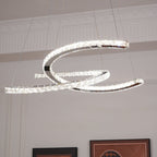 Side view of the lit Clérachic pendant, its steel crescents trimmed with crystals and hung by thin cables.