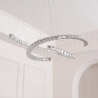 Unlit Clérachic crystal pendant seen from below, its two steel crescents catching light beside an arched doorway.