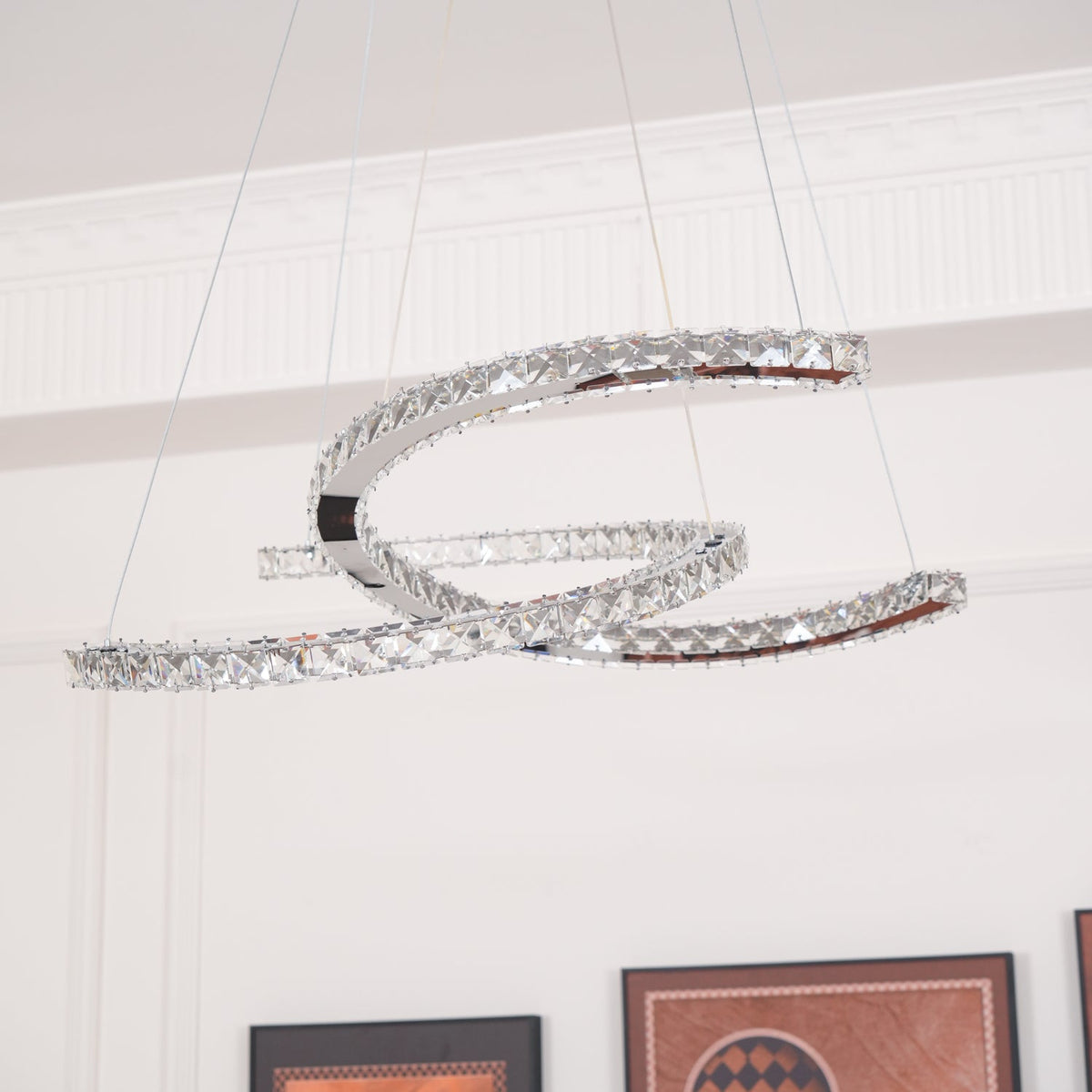 Unlit Clérachic crystal pendant in a white room with a cornice, hanging from thin cables.