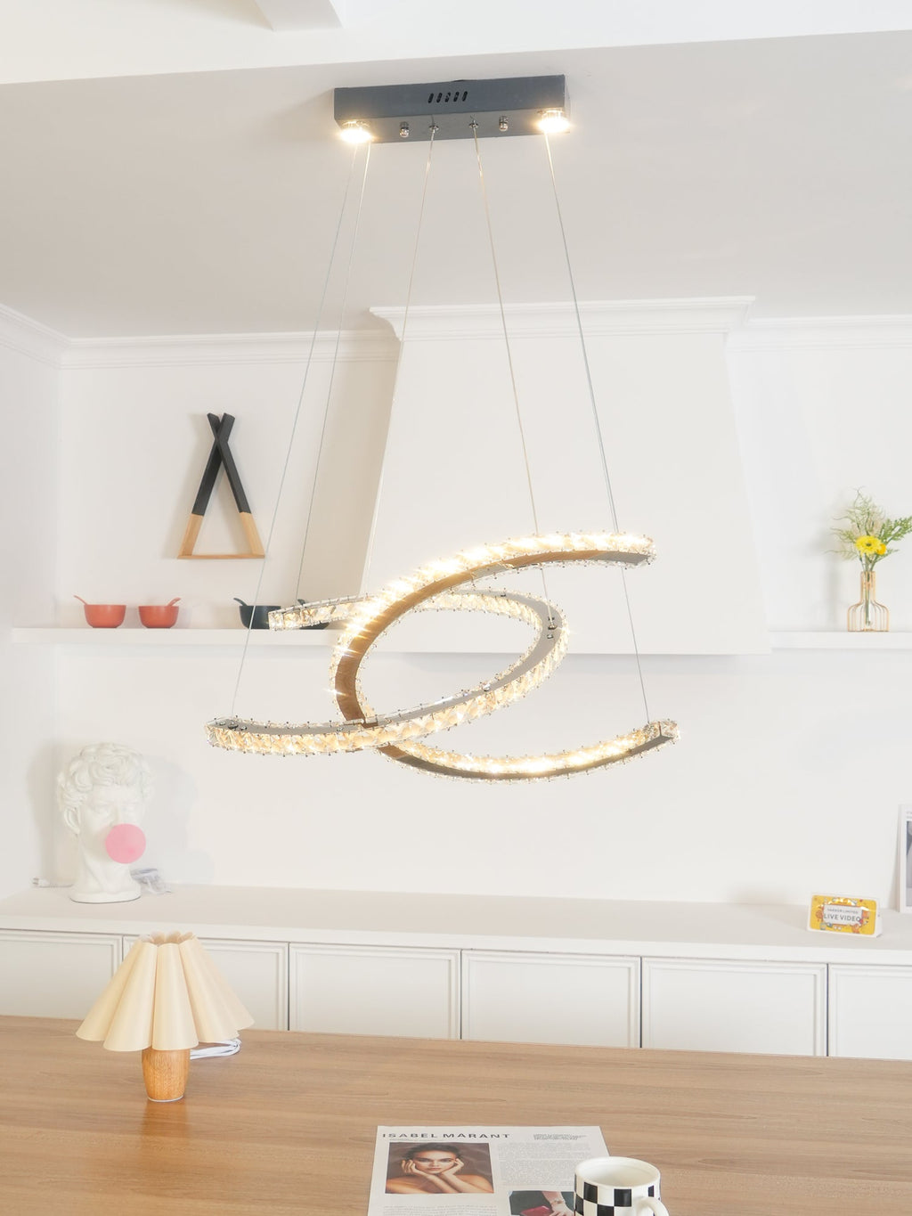 Clérachic crescent pendant with a dark ceiling canopy and two spot lights, above a wooden table in a white room.