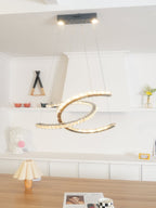 Clérachic crescent pendant with a dark ceiling canopy and two spot lights, above a wooden table in a white room.