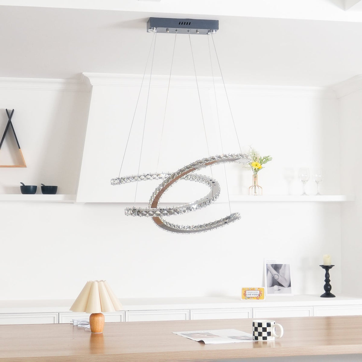 Unlit Clérachic crystal pendant under a dark canopy, with a shelf of glasses and a wooden table behind.