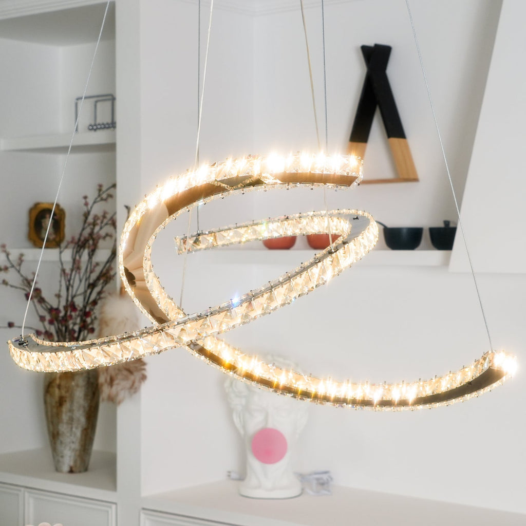 Close view of the Clérachic pendant lit, its crystals sparkling, with a vase of dried stems and a plaster bust below.
