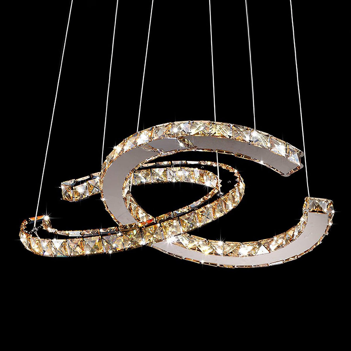 Cognac-toned Clérachic crystal pendant lit against black, its facets sparkling on the two crescents.