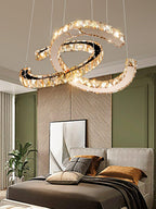 Clérachic crystal pendant lit above a bed with brown bedding, in a room with olive wall panels and an abstract picture.