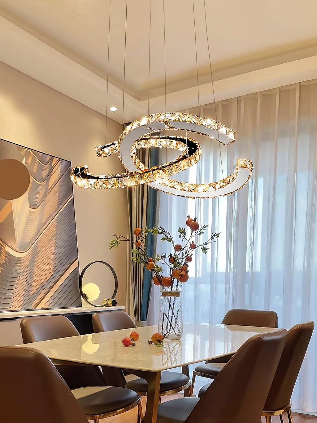 Clérachic crescent pendant lit warm above a marble-top dining table with brown leather chairs and sheer curtains.