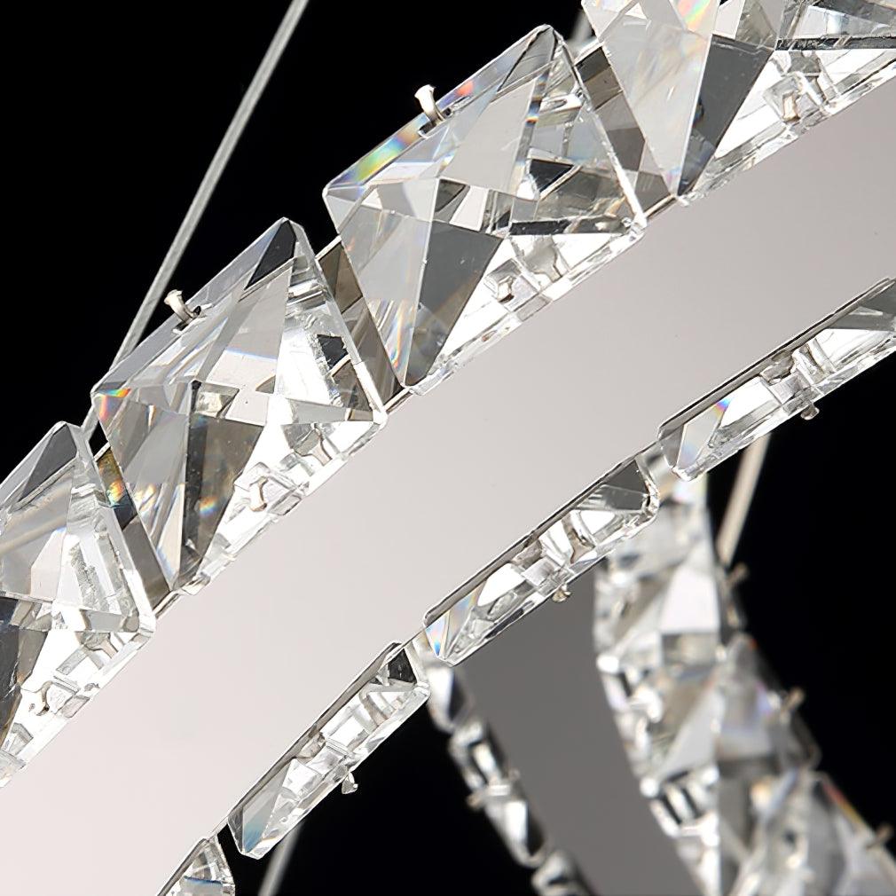 Close view of the large faceted crystals set along the polished steel band of this Clérachic pendant.
