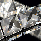 Macro view of square-cut crystals and the small metal pins that hold them on this Clérachic pendant.