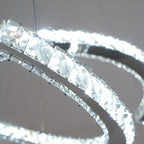 Close view of the lit crystals along one crescent of this Clérachic pendant, glowing white against a grey ceiling.