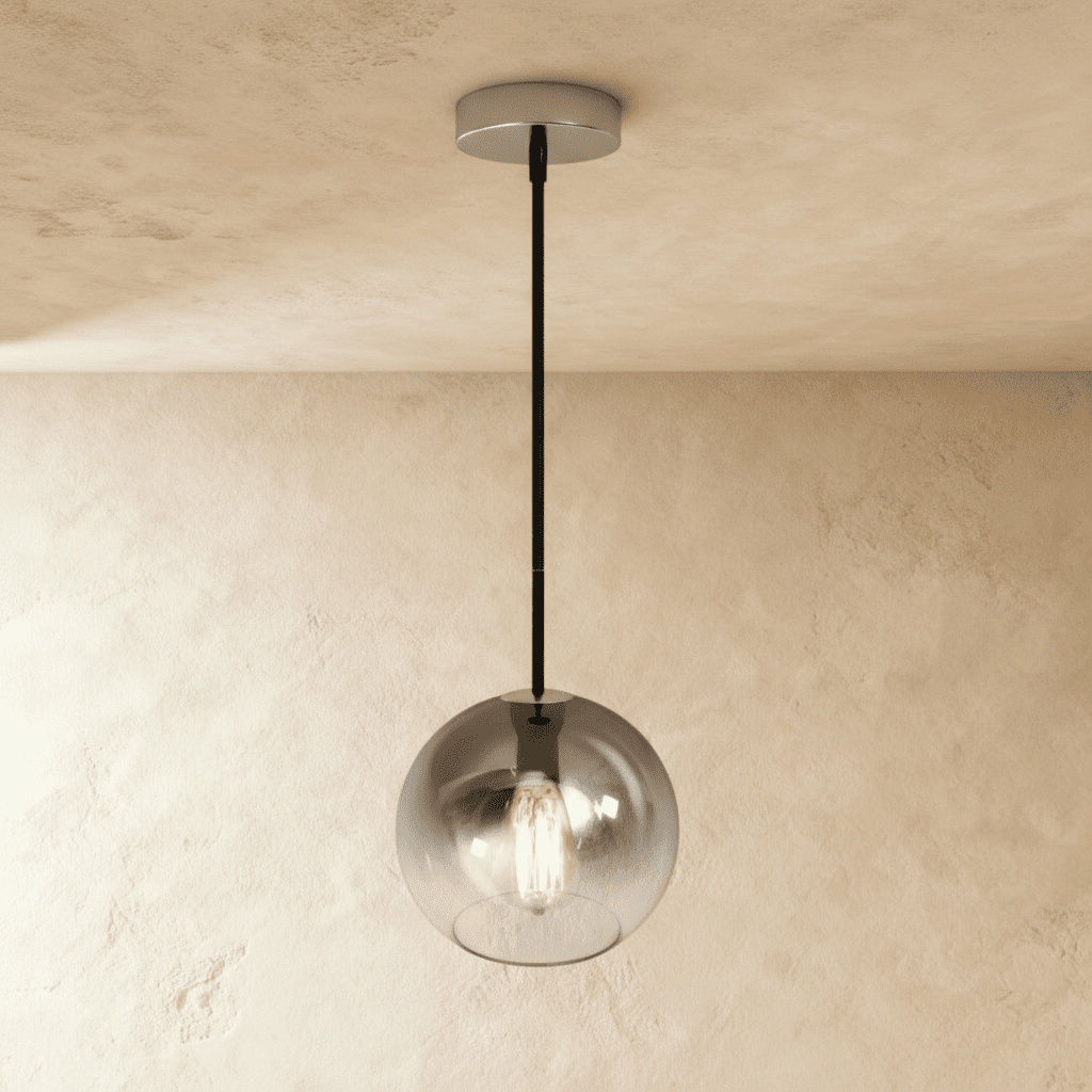 Clérachic silver-finish glass sphere pendant drops on a black cord from a textured plaster ceiling and wall.