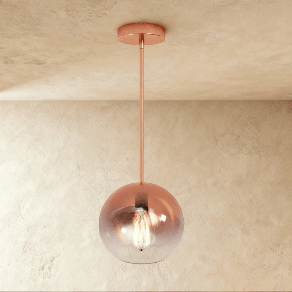 Clérachic rose gold glass sphere pendant catches warm light against a soft plaster ceiling and wall backdrop.