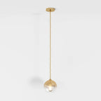 Clérachic gold-toned pendant light shown full drop, glass sphere shade lit from within on a white backdrop.
