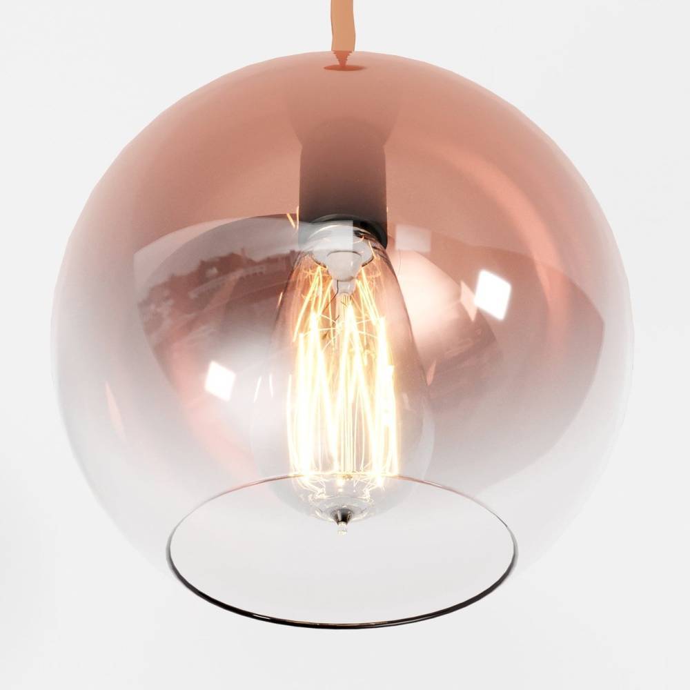 Clérachic extreme close-up of the rose gold gradient glass sphere, filament bulb glowing warm at its centre.