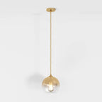 Clérachic champagne pendant light hangs on a matching cord, glass sphere shade lit against a white backdrop.