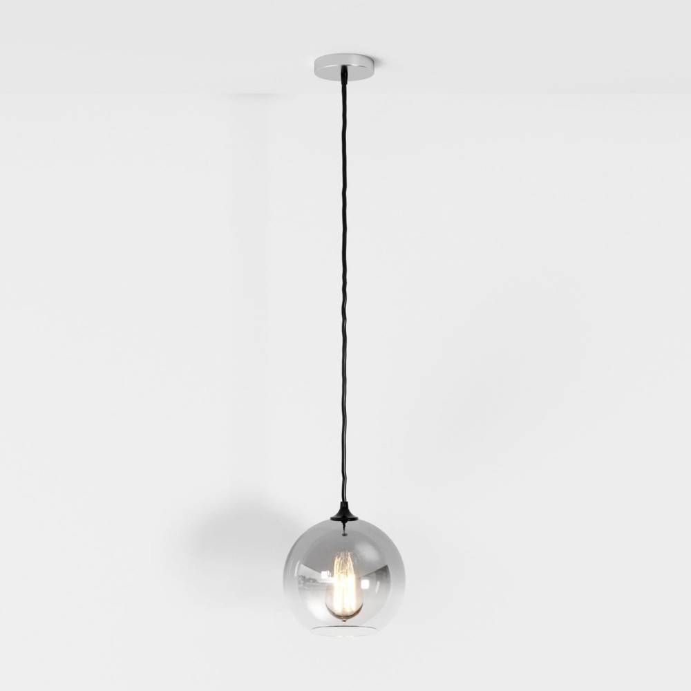 Clérachic silver-finish pendant light drops from a chrome ceiling canopy, glass sphere glowing softly white.