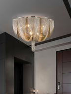 Smaller view of a Clérachic chain ceiling light in a dark-walled room beside a dark door and a table with glasses.