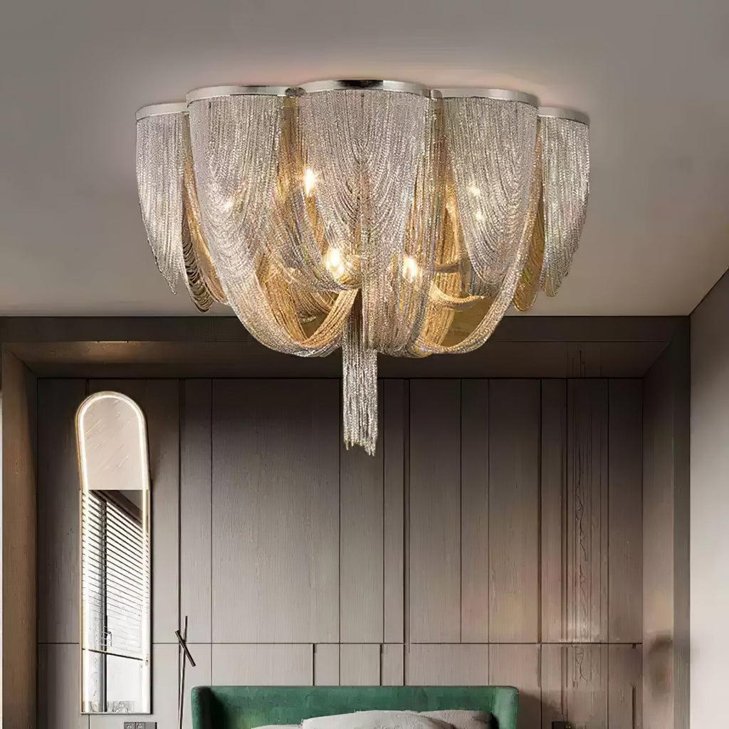 Clérachic silver chain ceiling light above a dark panelled wall, an arched mirror and a green headboard.