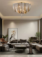 Clérachic chain ceiling light above a living room with a modular sofa, a large abstract print and a glass coffee table.